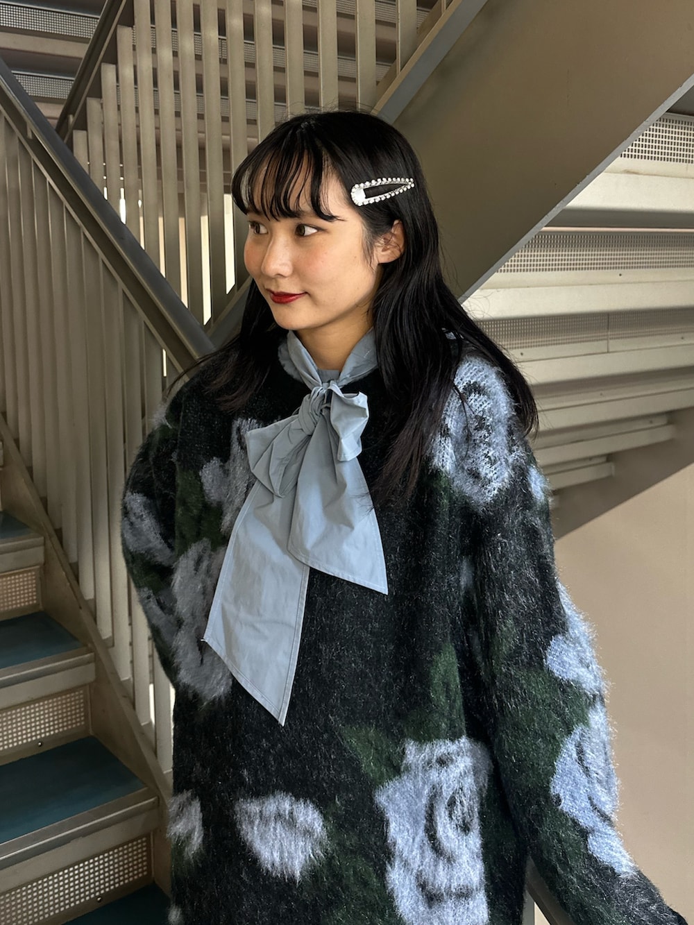 グレー系のスカート、ブラック系のニット/セーター、ブルー系のシャツ/ブラウスを着用したレディースの秋コーディネートの5枚目の写真