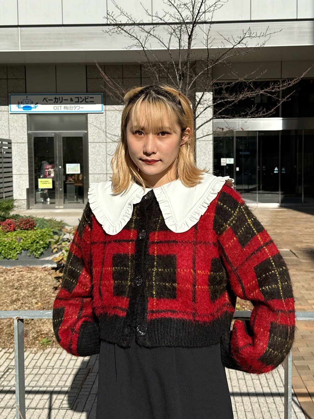 レッド系のカーディガン/ボレロ、ブラック系のワンピース、ブラック系のブーツを着用したレディースの冬コーディネートの3枚目の写真