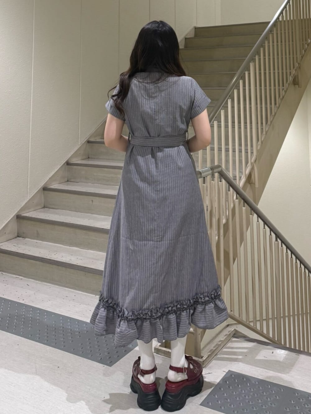 グレー系のワンピース、レッド系のパンプスを着用したレディースの春コーディネートの3枚目の写真