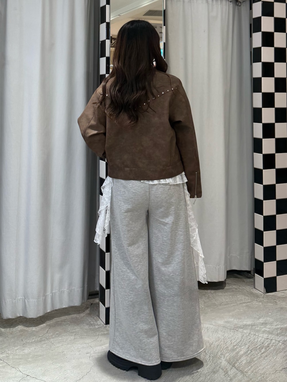 ブラック系のニット/セーター、ブラウン系のブルゾン、グレー系のスウェットパンツを着用したレディースの冬コーディネートの4枚目の写真