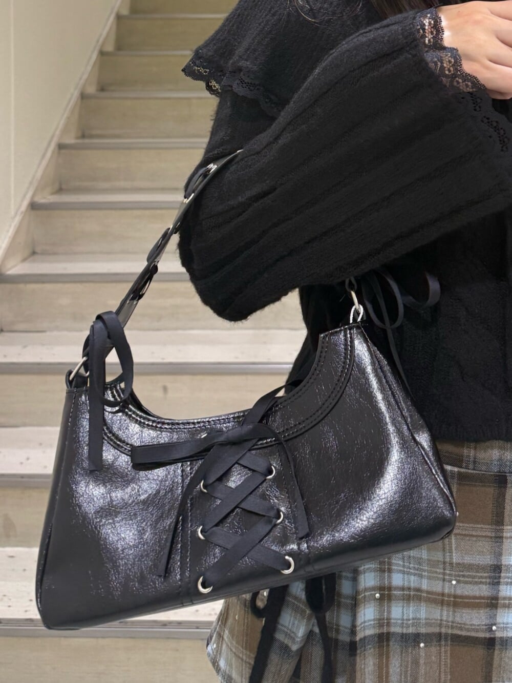 ブラック系のブーツ、ブラウン系のスカート、ブラック系のハンドバッグを着用したレディースの冬コーディネートの7枚目の写真