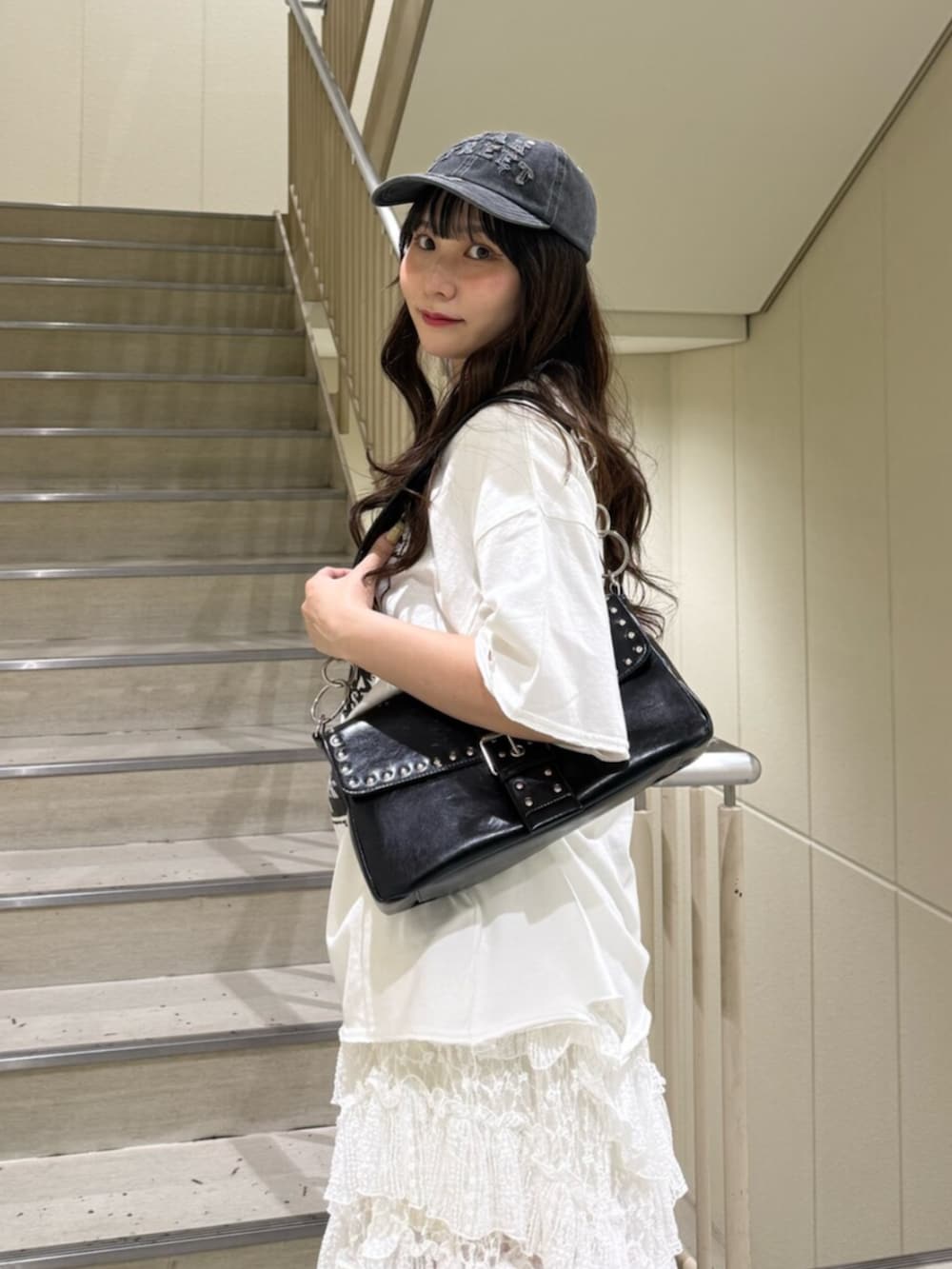 ブラック系のブーツ、ホワイト系のTシャツ/カットソー、ブラック系のハンドバッグを着用したレディースの春コーディネートの7枚目の写真