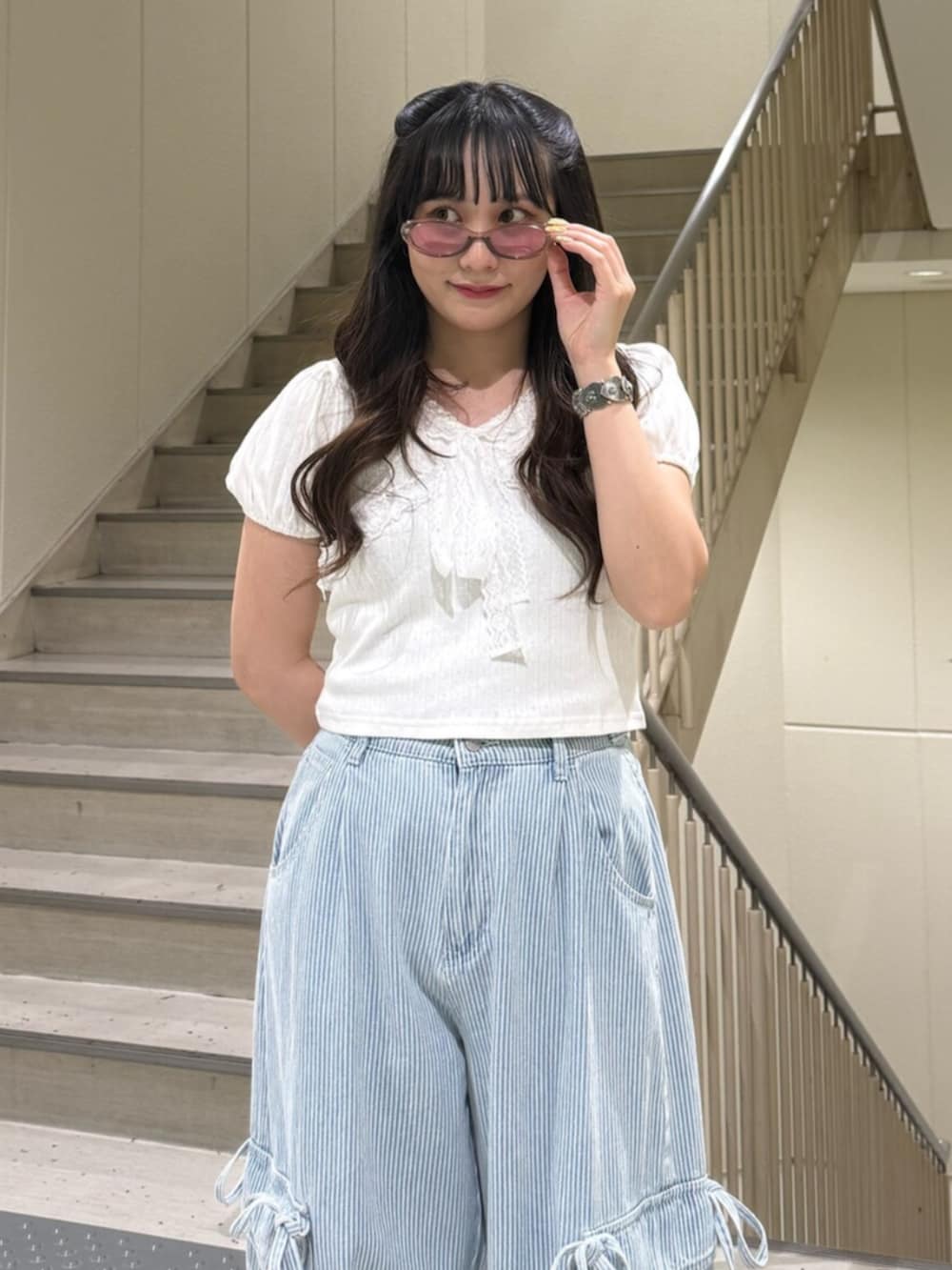 ブラック系のブーツ、ホワイト系のTシャツ/カットソー、ブルー系のデニムパンツを着用したレディースの春コーディネートの5枚目の写真