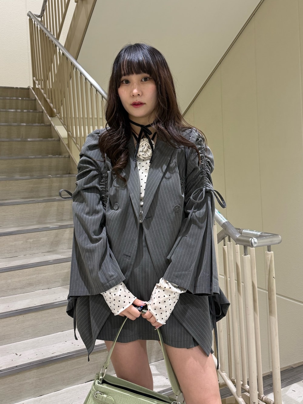 ホワイト系のTシャツ/カットソー、グレー系のスカート、グレー系のテーラードジャケットを着用したレディースの冬コーディネートの7枚目の写真