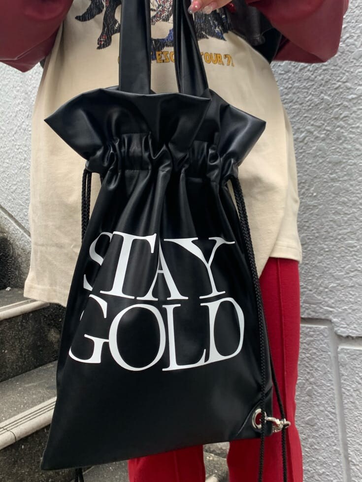 ブラック系のバックパック/リュック、ホワイト系のTシャツ/カットソー、ブラウン系のブルゾンを着用したレディースの秋コーディネートの6枚目の写真