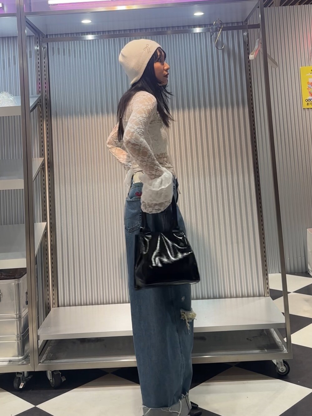 ホワイト系のTシャツ/カットソー、ブルー系のデニムパンツ、ブラック系のハンドバッグを着用したレディースの秋コーディネートの3枚目の写真