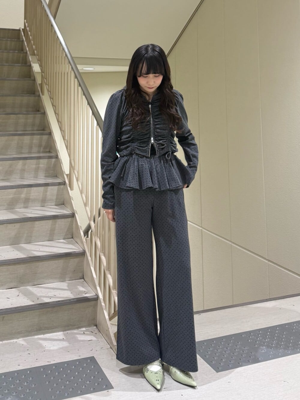 グレー系のスウェットパンツ、ブラック系のパーカー、グリーン系のパンプスを着用したレディースの春コーディネートの6枚目の写真