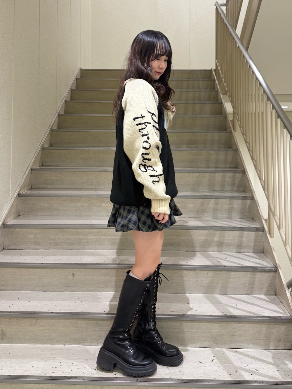 ブラック系のニット/セーター、グリーン系のワンピース、ホワイト系のハンドバッグを着用したレディースの冬コーディネートの2枚目の写真