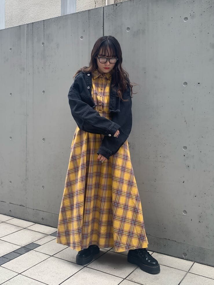 イエロー系のワンピース、ブラック系のデニムジャケット、ブラック系のサングラスを着用したレディースの春コーディネートの2枚目の写真