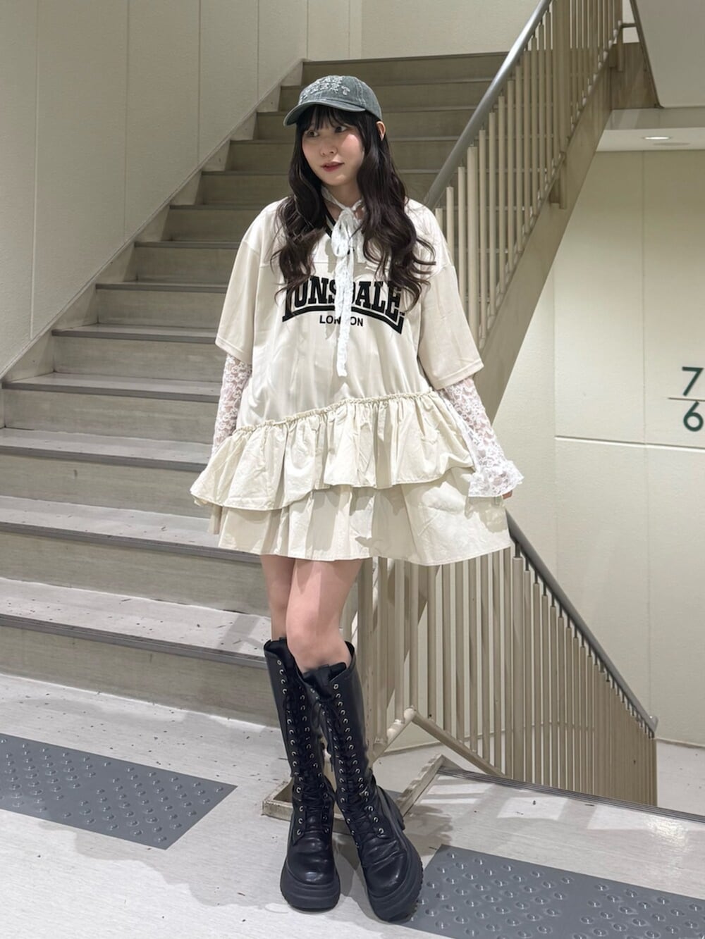 ブラック系のブーツ、ホワイト系のワンピース、ホワイト系のTシャツ/カットソーを着用したレディースの春コーディネートの5枚目の写真