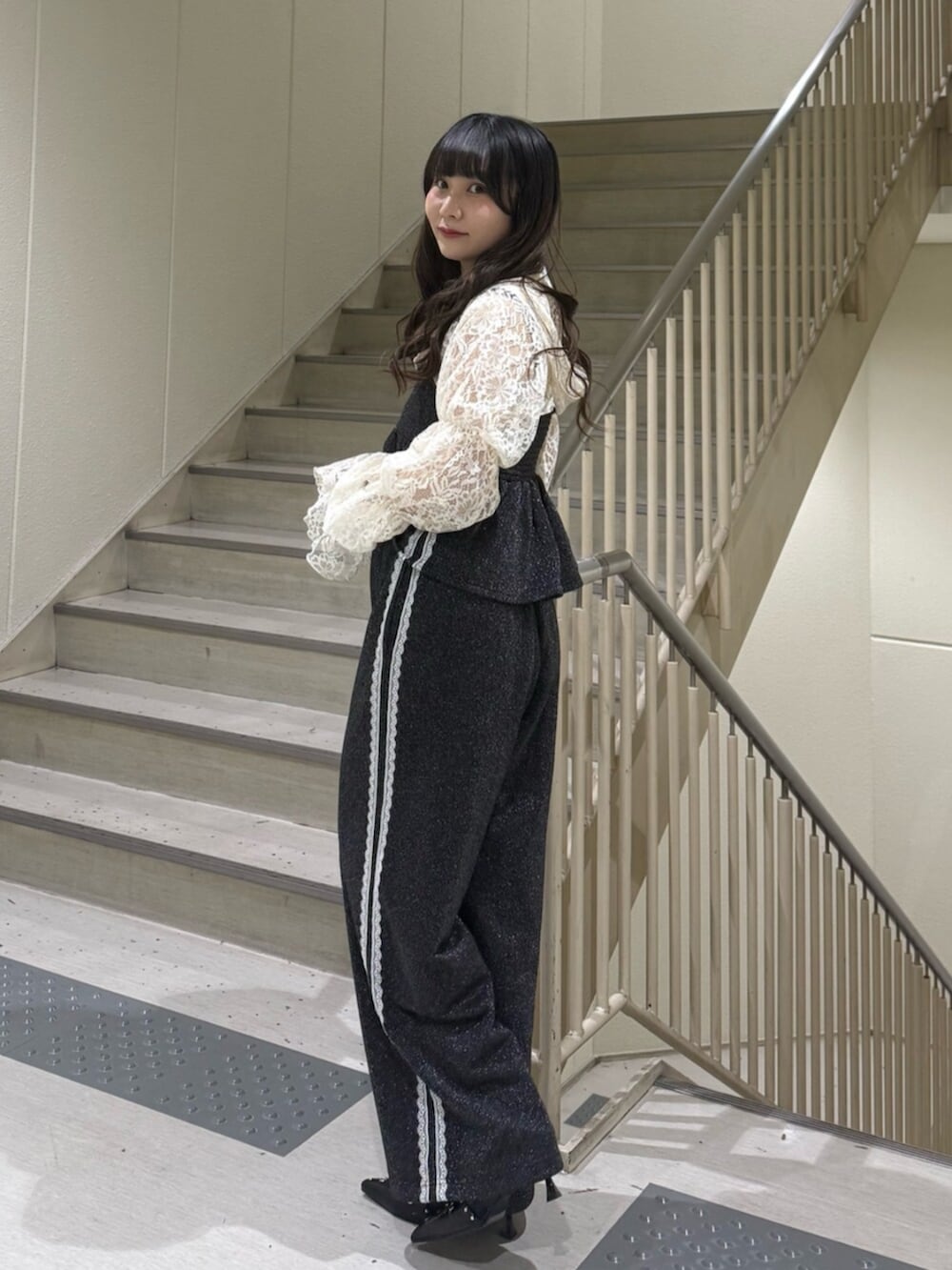 ブラック系のパンプス、ホワイト系のカーディガン/ボレロ、ブラック系のキャミソールを着用したレディースの春コーディネートの4枚目の写真