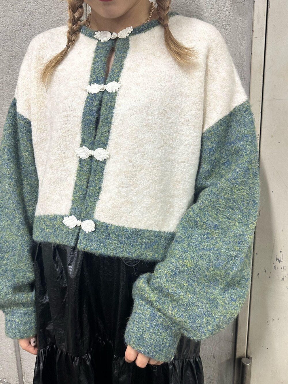 ホワイト系のカーディガン/ボレロ、ブラック系のスカート、ブラック系のブーツを着用したレディースの秋コーディネートの6枚目の写真