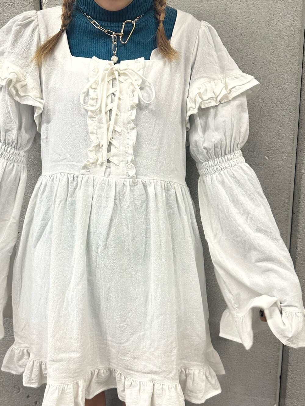 ホワイト系のワンピース、ブラック系のブーツ、ブルー系のニット/セーターを着用したレディースの秋コーディネートの5枚目の写真