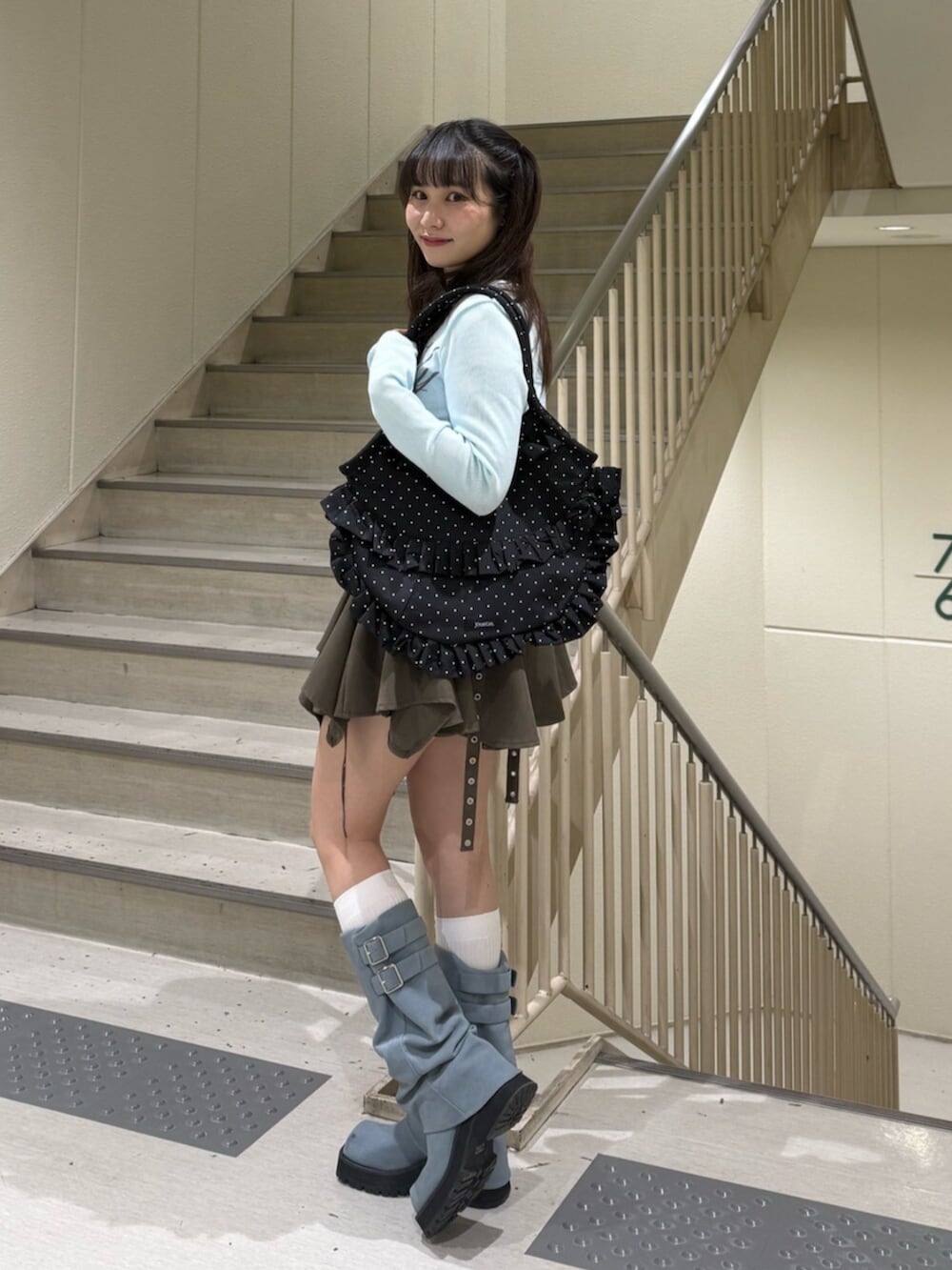 ベージュ系のスカート、ブルー系のTシャツ/カットソー、ブラック系のトートバッグを着用したレディースの春コーディネートの2枚目の写真