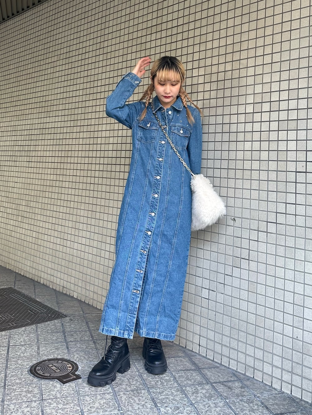 ブルー系のワンピース、ホワイト系のハンドバッグ、ブラック系のブーツを着用したレディースの冬コーディネートの3枚目の写真