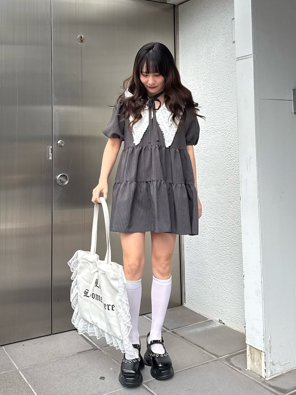 グレー系のワンピース、ホワイト系のトートバッグを着用したレディースの冬コーディネートの5枚目の写真