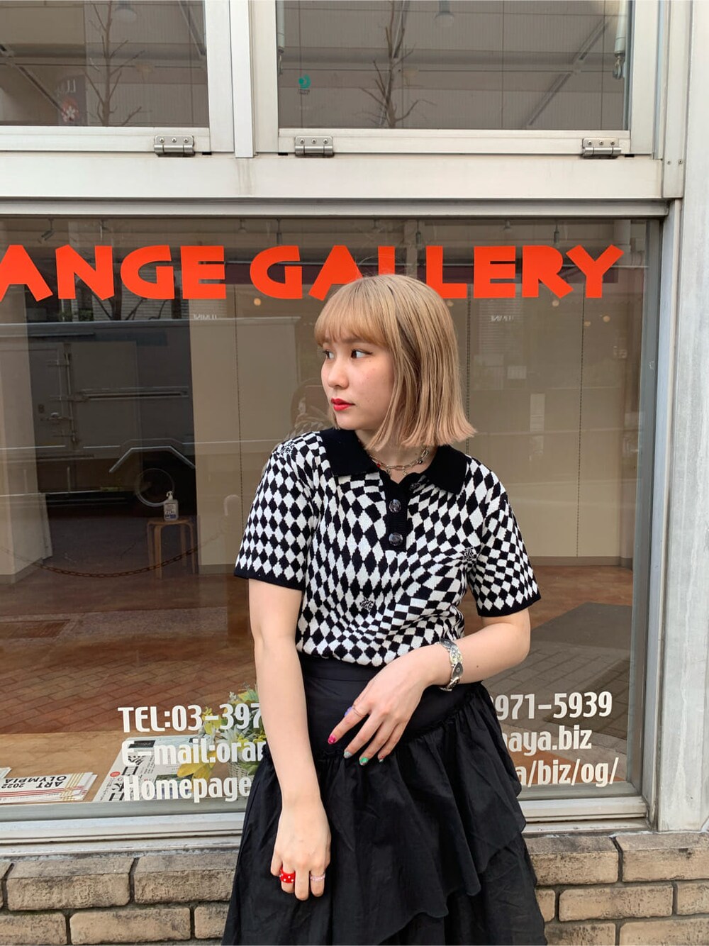 ブラック系のニット/セーター、ブラック系のスカート、シルバー系のブレスレットを着用したレディースの春コーディネートの3枚目の写真