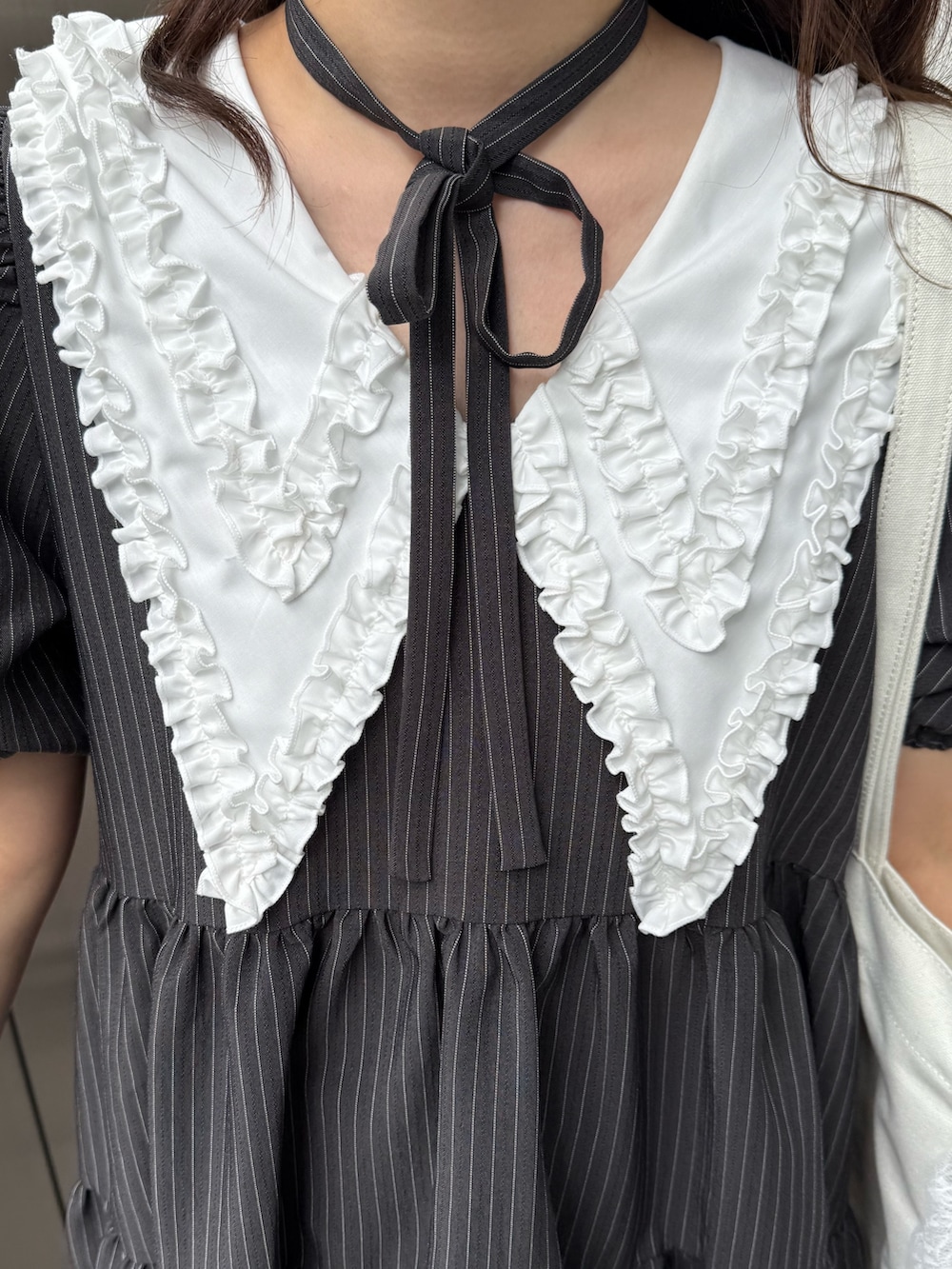 グレー系のワンピース、ホワイト系のトートバッグを着用したレディースの冬コーディネートの6枚目の写真