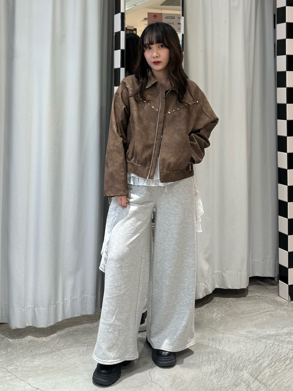 ブラック系のニット/セーター、ブラウン系のブルゾン、グレー系のスウェットパンツを着用したレディースの冬コーディネートの7枚目の写真