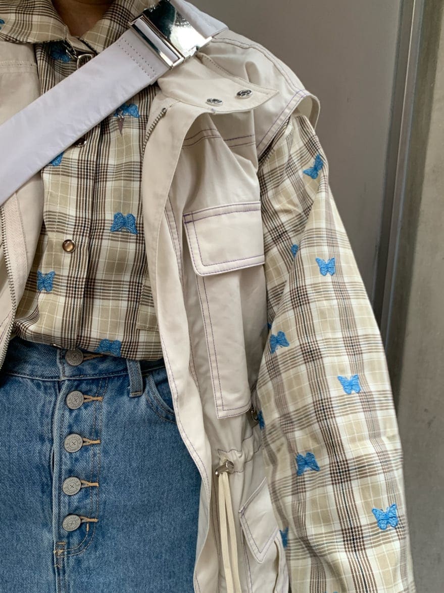 ブルー系のデニムスカート、ベージュ系のシャツ/ブラウス、ホワイト系のベストを着用したレディースの秋コーディネートの4枚目の写真