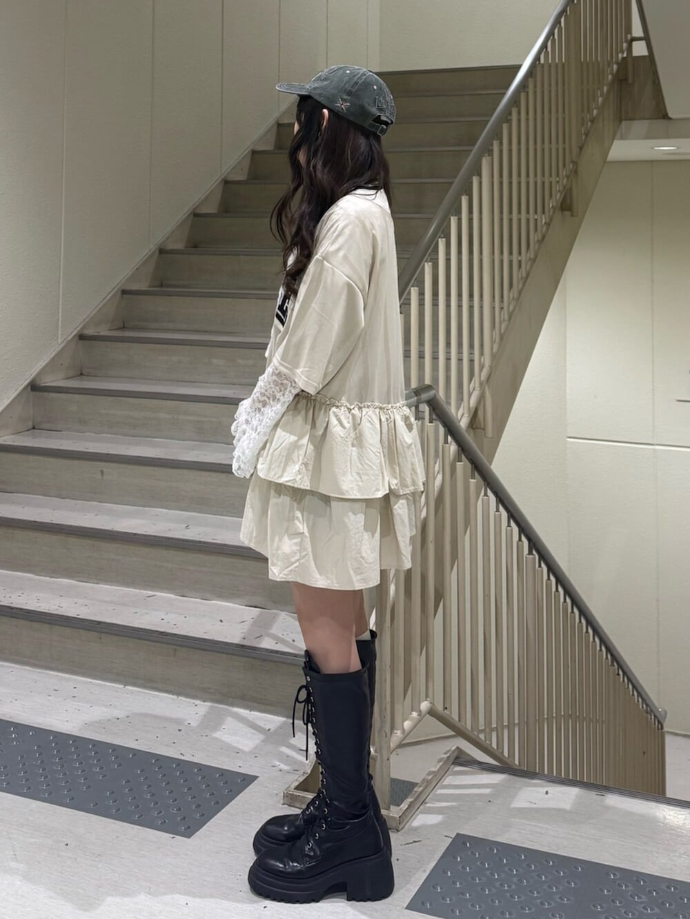 ブラック系のブーツ、ホワイト系のワンピース、ホワイト系のTシャツ/カットソーを着用したレディースの春コーディネートの3枚目の写真