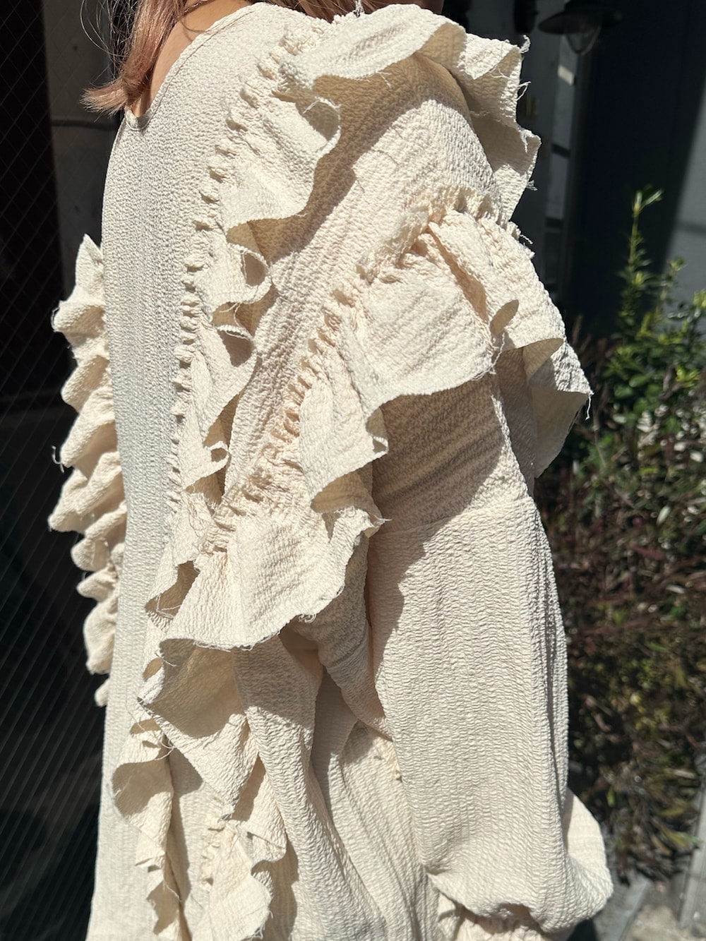 ブルー系のデニムパンツ、ホワイト系のシャツ/ブラウス、ホワイト系のメッセンジャーバッグを着用したレディースの春コーディネートの5枚目の写真