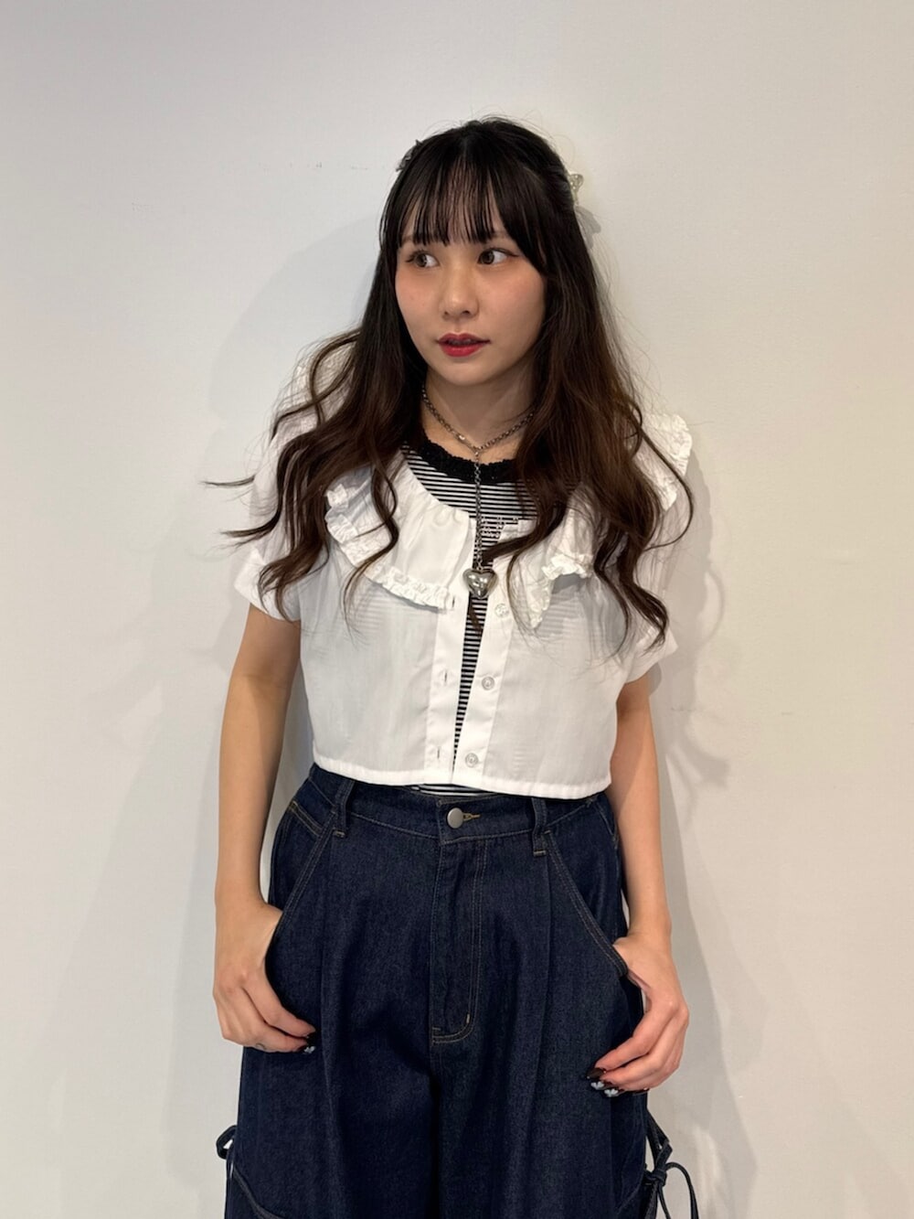 ブラック系のパンプス、ホワイト系のシャツ/ブラウス、ブルー系のデニムパンツを着用したレディースの春コーディネートの7枚目の写真
