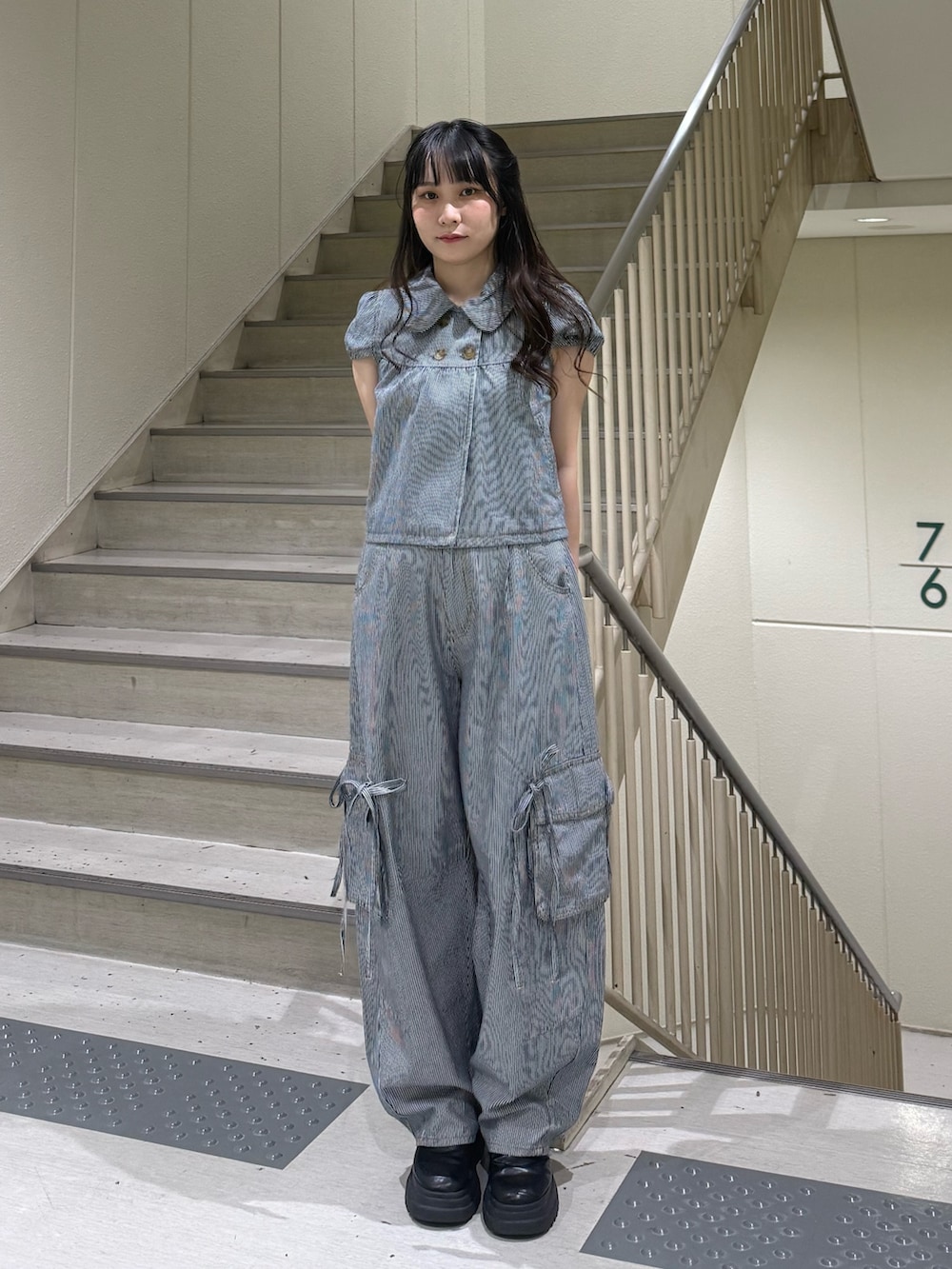 ブラック系のデニムパンツ、ブラック系のブーツ、ブラック系のその他トップスを着用したレディースの春コーディネートの2枚目の写真