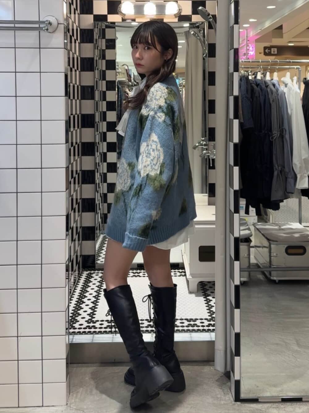 ブラック系のブーツ、ホワイト系のシャツ/ブラウス、ブルー系のニット/セーターを着用したレディースの冬コーディネートの2枚目の写真