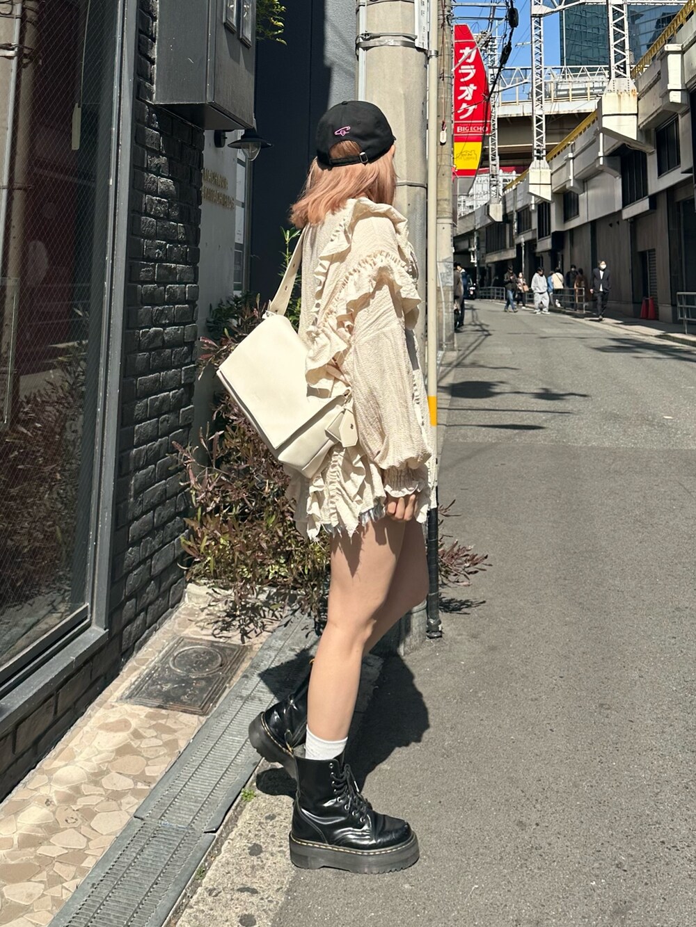 ブルー系のデニムパンツ、ホワイト系のシャツ/ブラウス、ホワイト系のメッセンジャーバッグを着用したレディースの春コーディネートの2枚目の写真