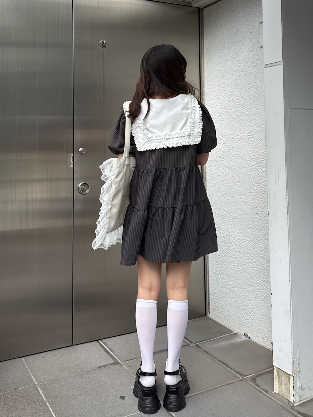 グレー系のワンピース、ホワイト系のトートバッグを着用したレディースの冬コーディネートの4枚目の写真