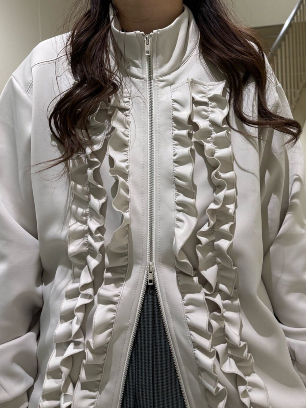 ブラック系のブーツ、ホワイト系のジャージ、その他のスカートを着用したレディースの冬コーディネートの10枚目の写真