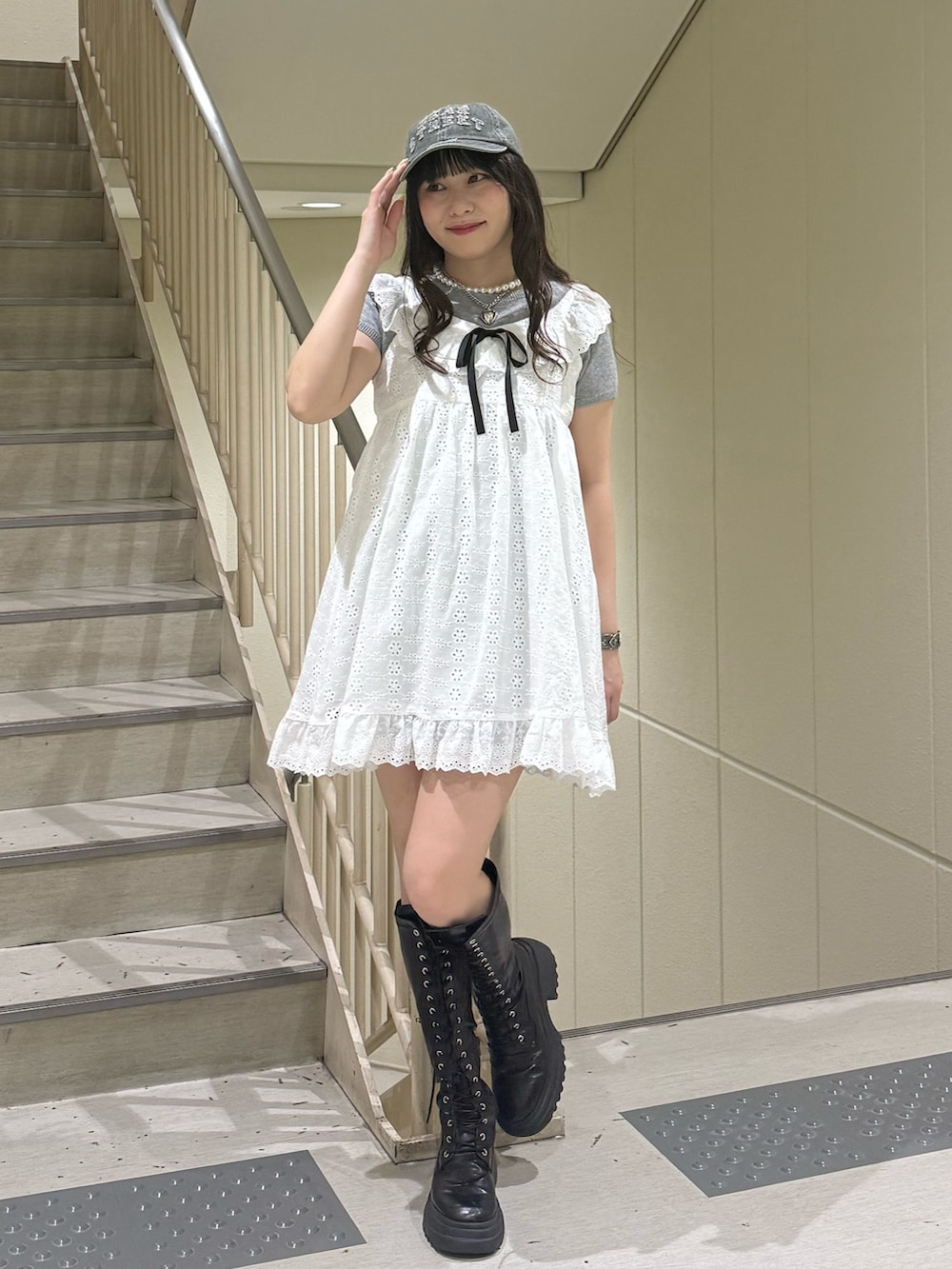 ホワイト系のワンピース、グレー系のTシャツ/カットソー、ブラック系のブーツを着用したレディースの春コーディネートの2枚目の写真