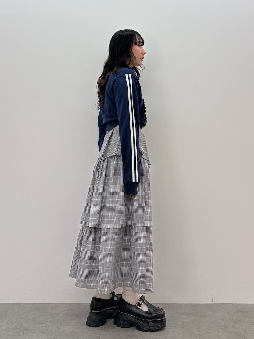 ブルー系のジャージ、グレー系のスカート、ブラック系のスニーカーを着用したレディースの春コーディネートの2枚目の写真