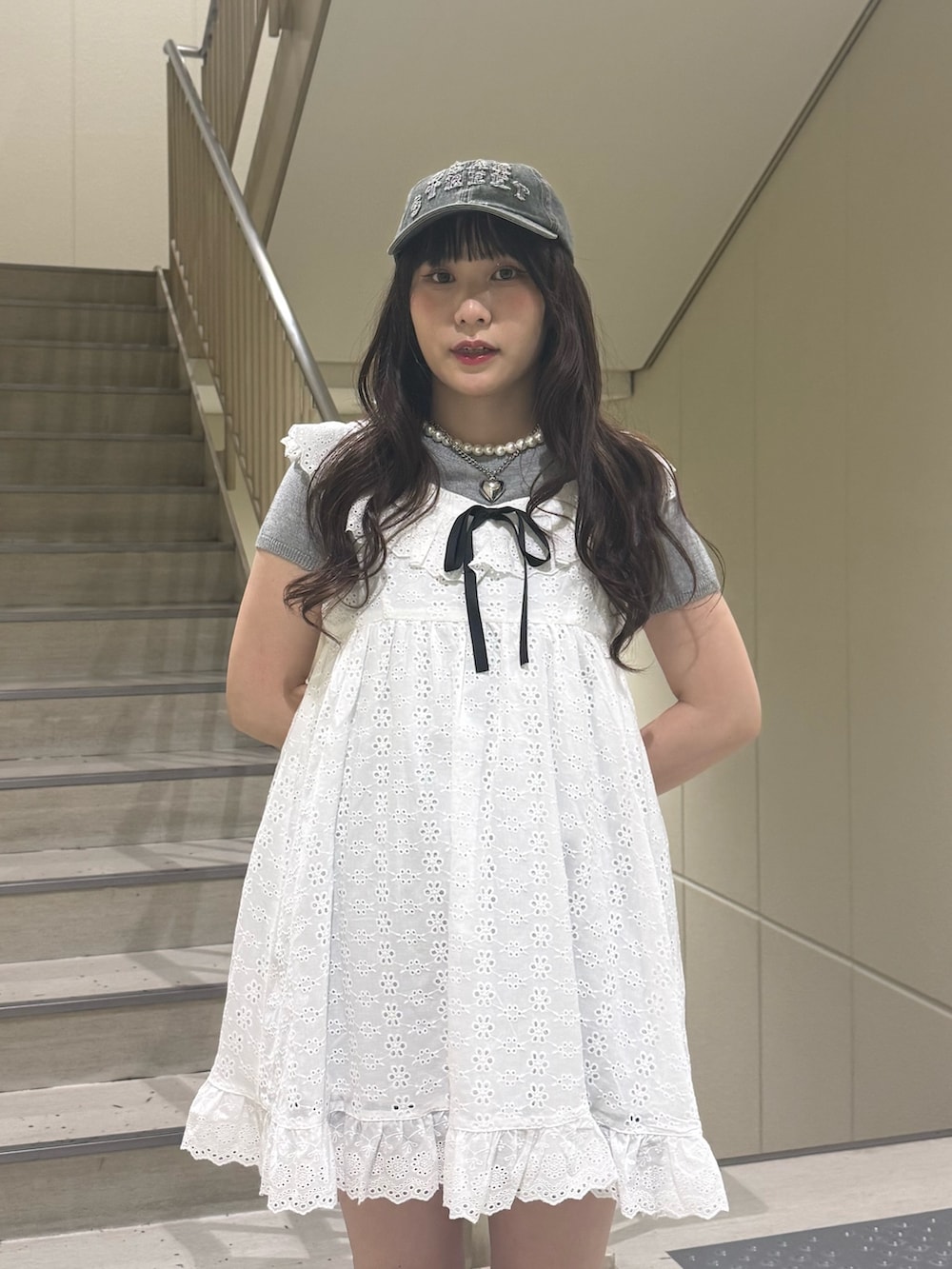 ホワイト系のワンピース、グレー系のTシャツ/カットソー、ブラック系のブーツを着用したレディースの春コーディネートの6枚目の写真