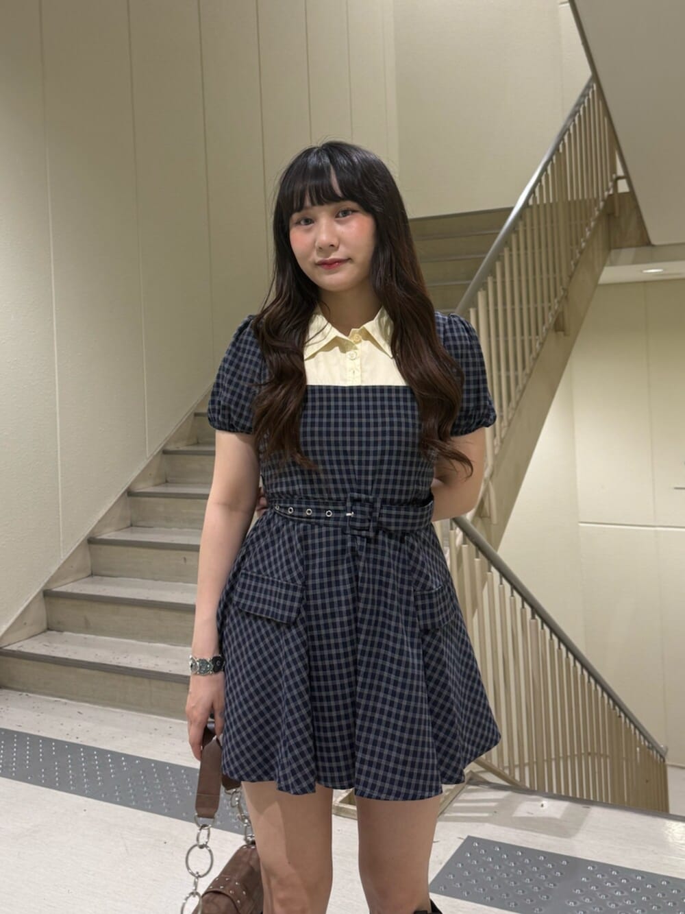 ブラウン系のハンドバッグ、ブラック系のブーツ、ブルー系のワンピースを着用したレディースの夏コーディネートの5枚目の写真