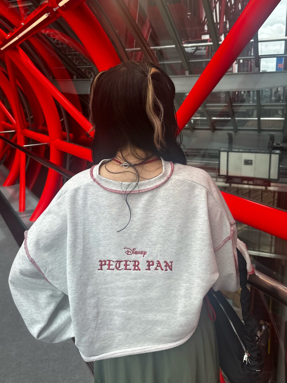 グレー系のスウェット、グリーン系のスカート、ブラック系のショルダーバッグを着用したレディースの夏コーディネートの6枚目の写真