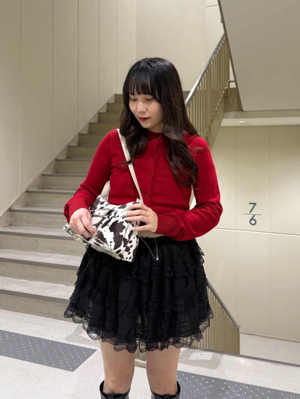 ブラック系のブーツ、ホワイト系のハンドバッグ、ブラック系のその他パンツを着用したレディースの春コーディネートの7枚目の写真