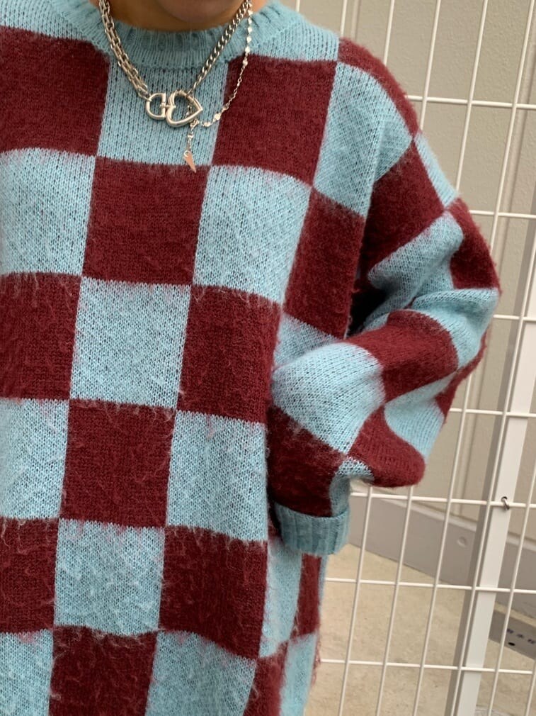 ブルー系のニット/セーター、レッド系のブーツを着用したレディースの秋コーディネートの5枚目の写真