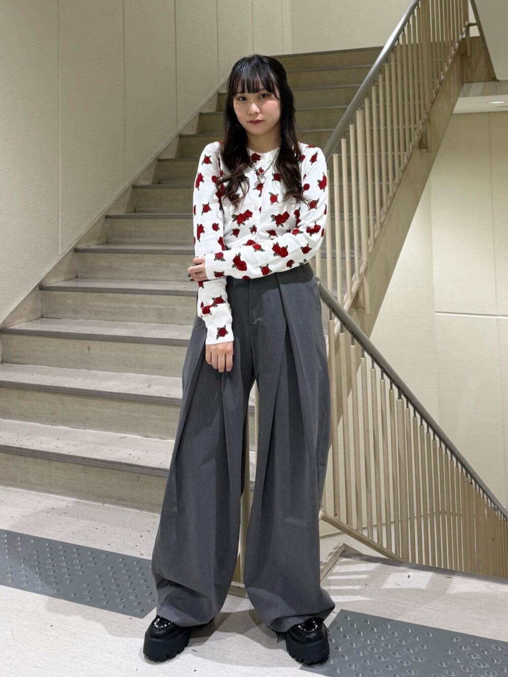 グレー系のスラックス、ホワイト系のカーディガン/ボレロ、ブラック系のローファーを着用したレディースの冬コーディネートの2枚目の写真