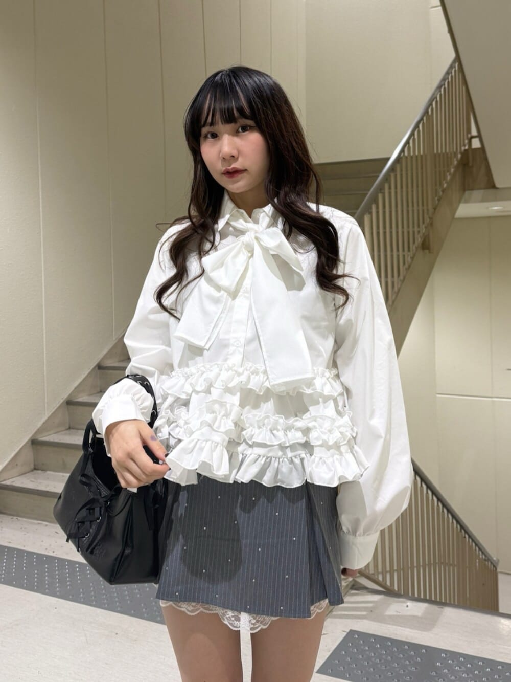 ブラック系のハンドバッグ、ブラック系のローファー、グレー系のスカートを着用したレディースの冬コーディネートの9枚目の写真