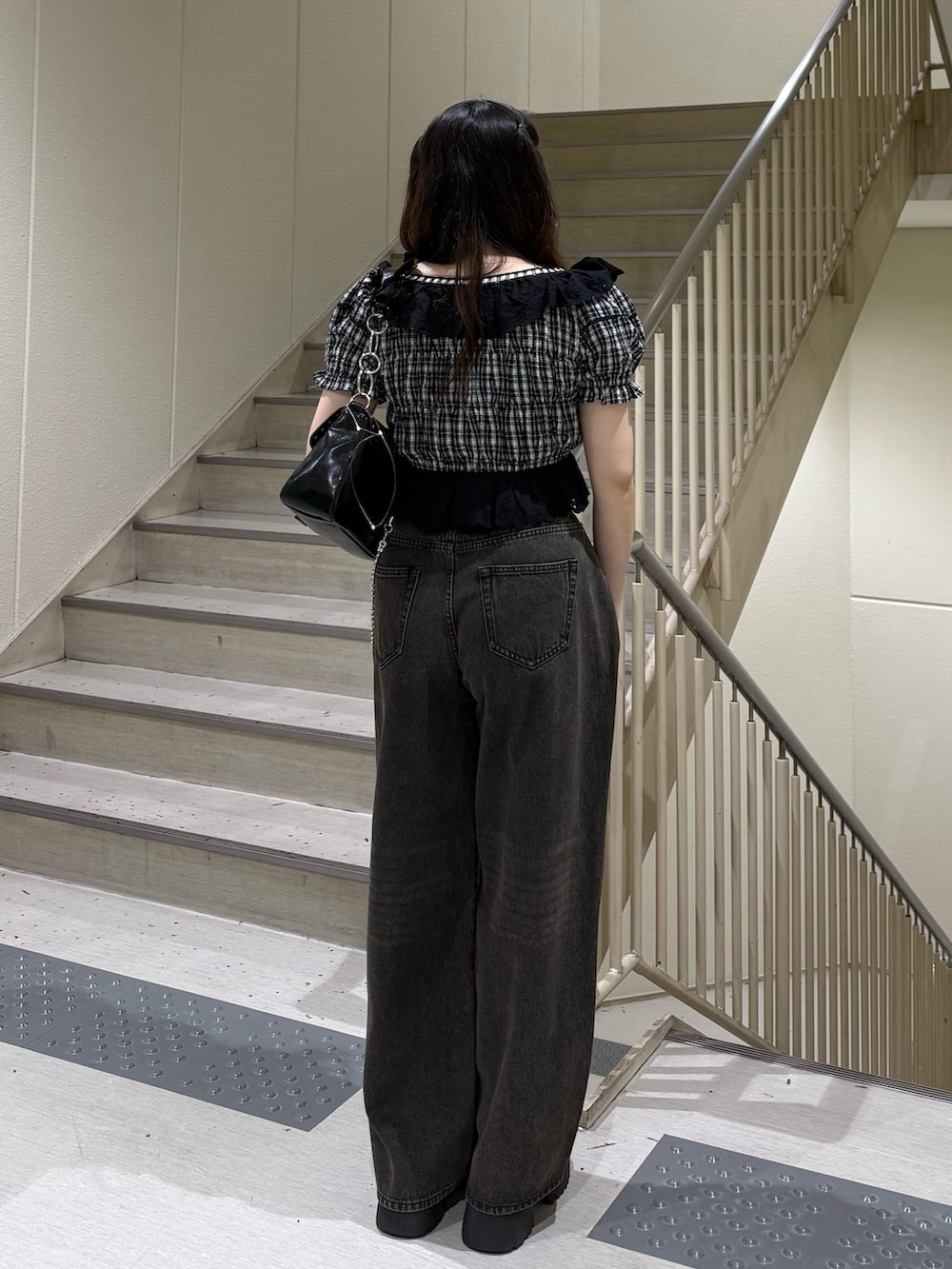 ブラック系のシャツ/ブラウス、ブラック系のデニムパンツ、ブラック系のハンドバッグを着用したレディースの春コーディネートの3枚目の写真