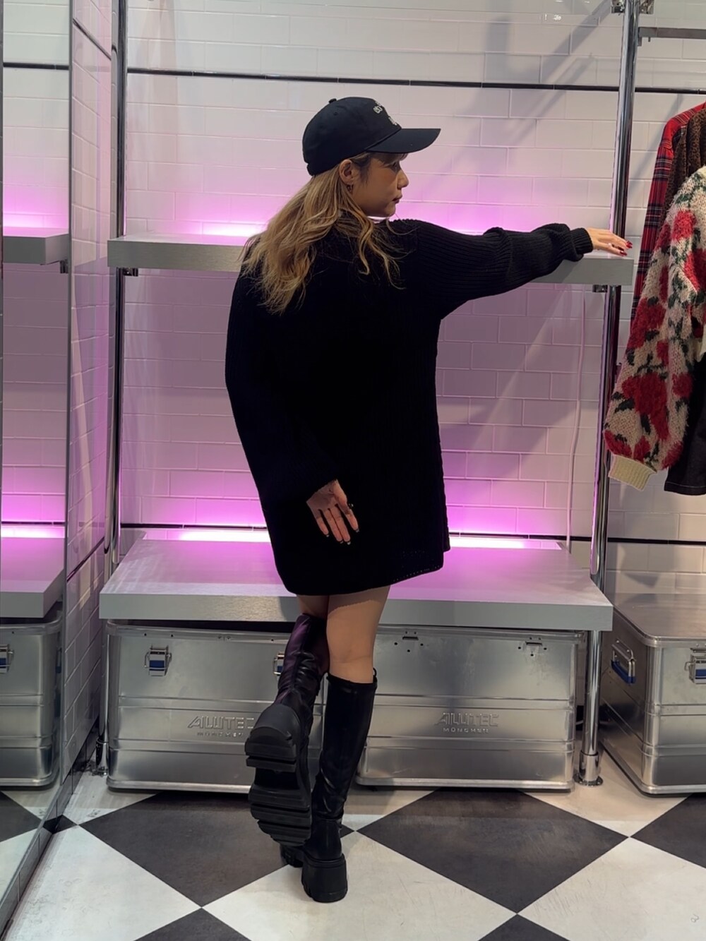 ブラック系のワンピース、ブラック系のブーツ、ブラック系のキャップを着用したレディースの冬コーディネートの3枚目の写真