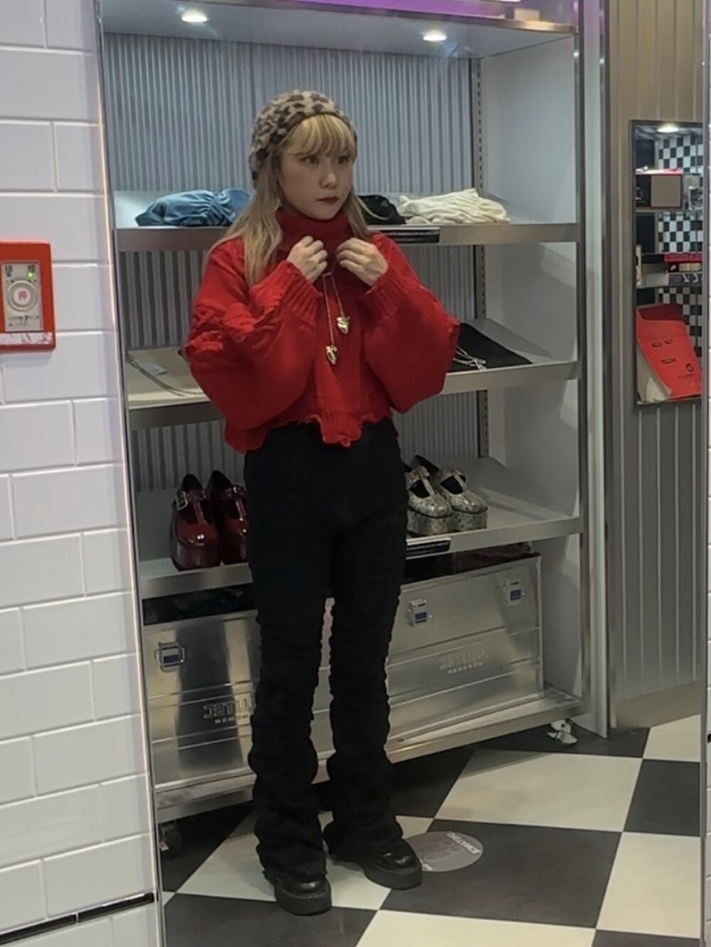 レッド系のニット/セーター、ブラック系のその他パンツ、ゴールド系のネックレスを着用したレディースの秋コーディネートの2枚目の写真