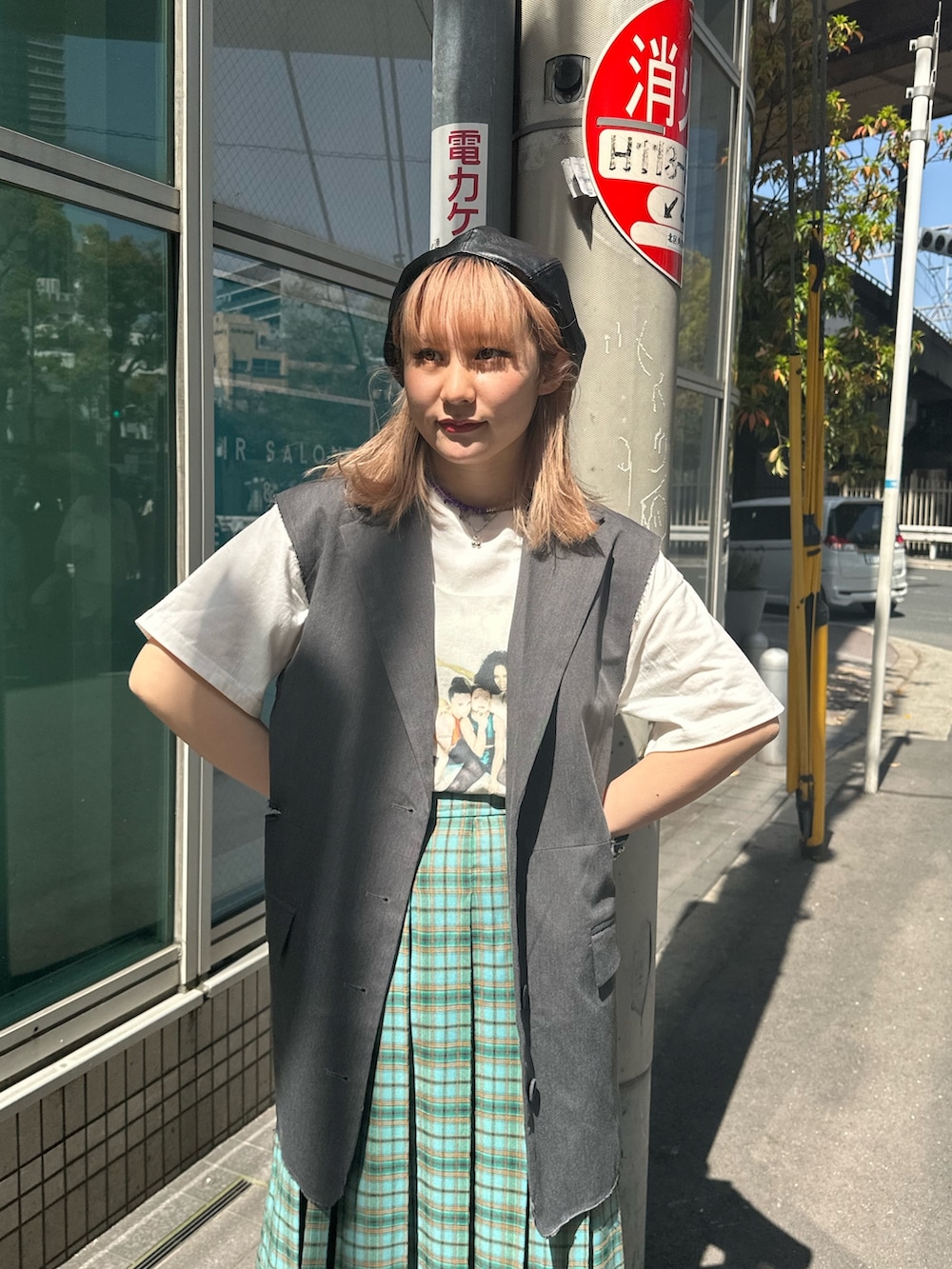 グリーン系のスカート、グレー系のベスト、ホワイト系のTシャツ/カットソーを着用したレディースの春コーディネートの4枚目の写真