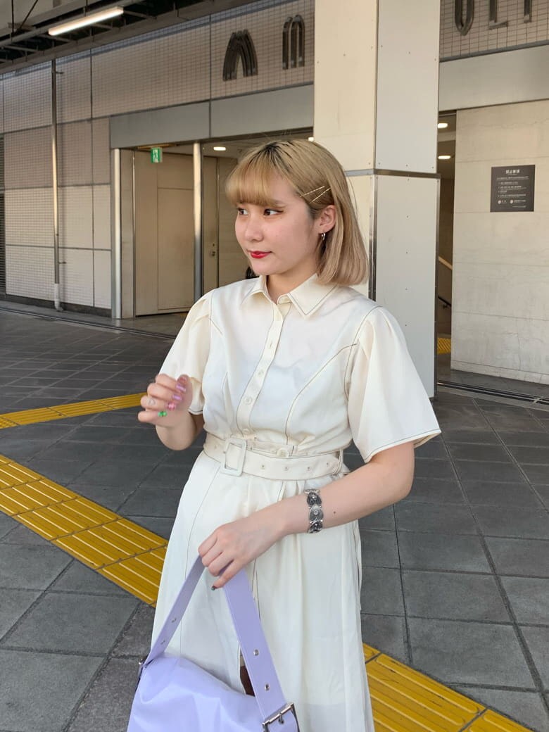 パープル系のハンドバッグ、ホワイト系のワンピース、シルバー系のブレスレットを着用したレディースの夏コーディネートの3枚目の写真