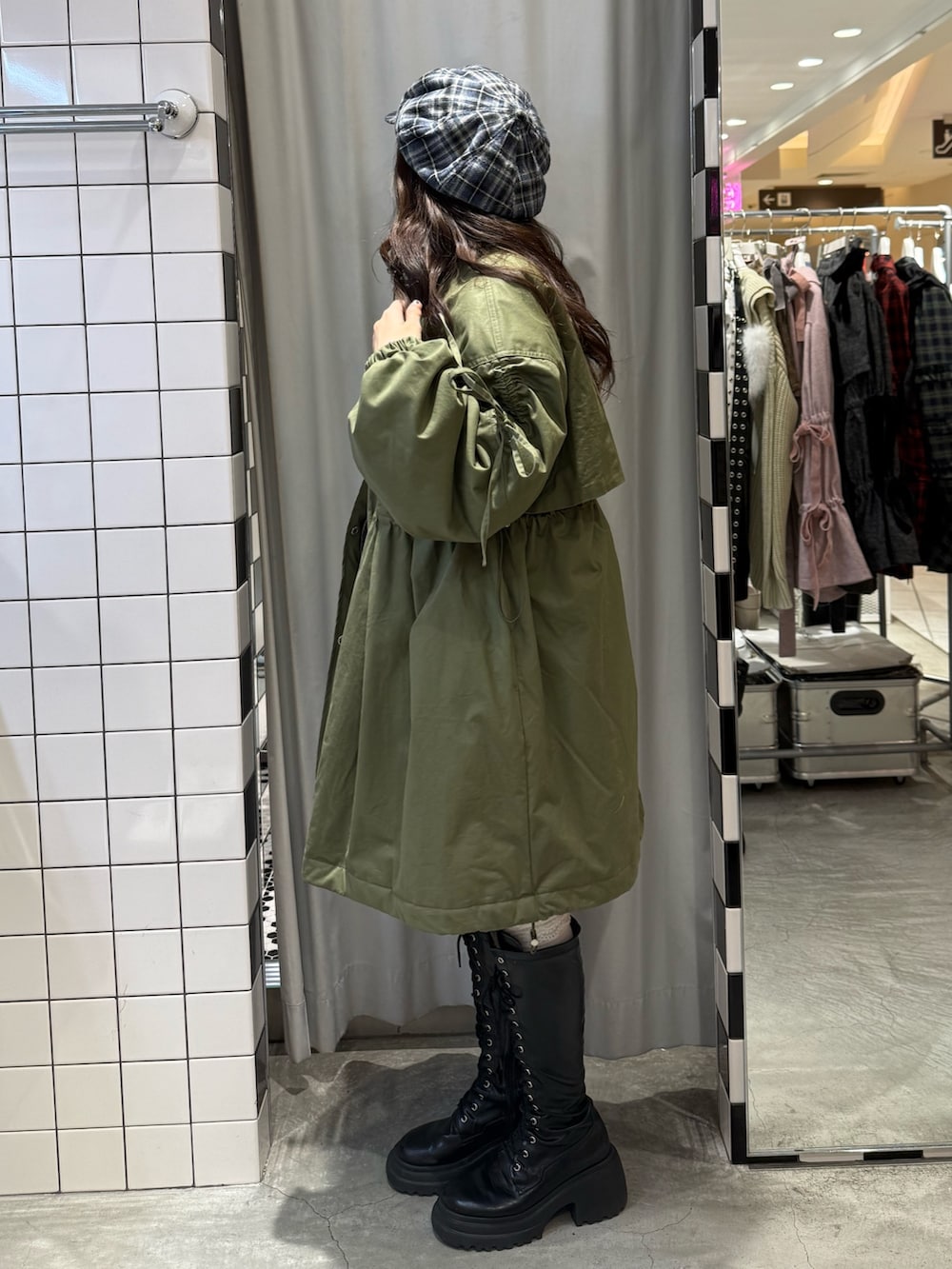 グリーン系のモッズコート、グレー系のニット/セーター、ブルー系のスカートを着用したレディースの冬コーディネートの3枚目の写真