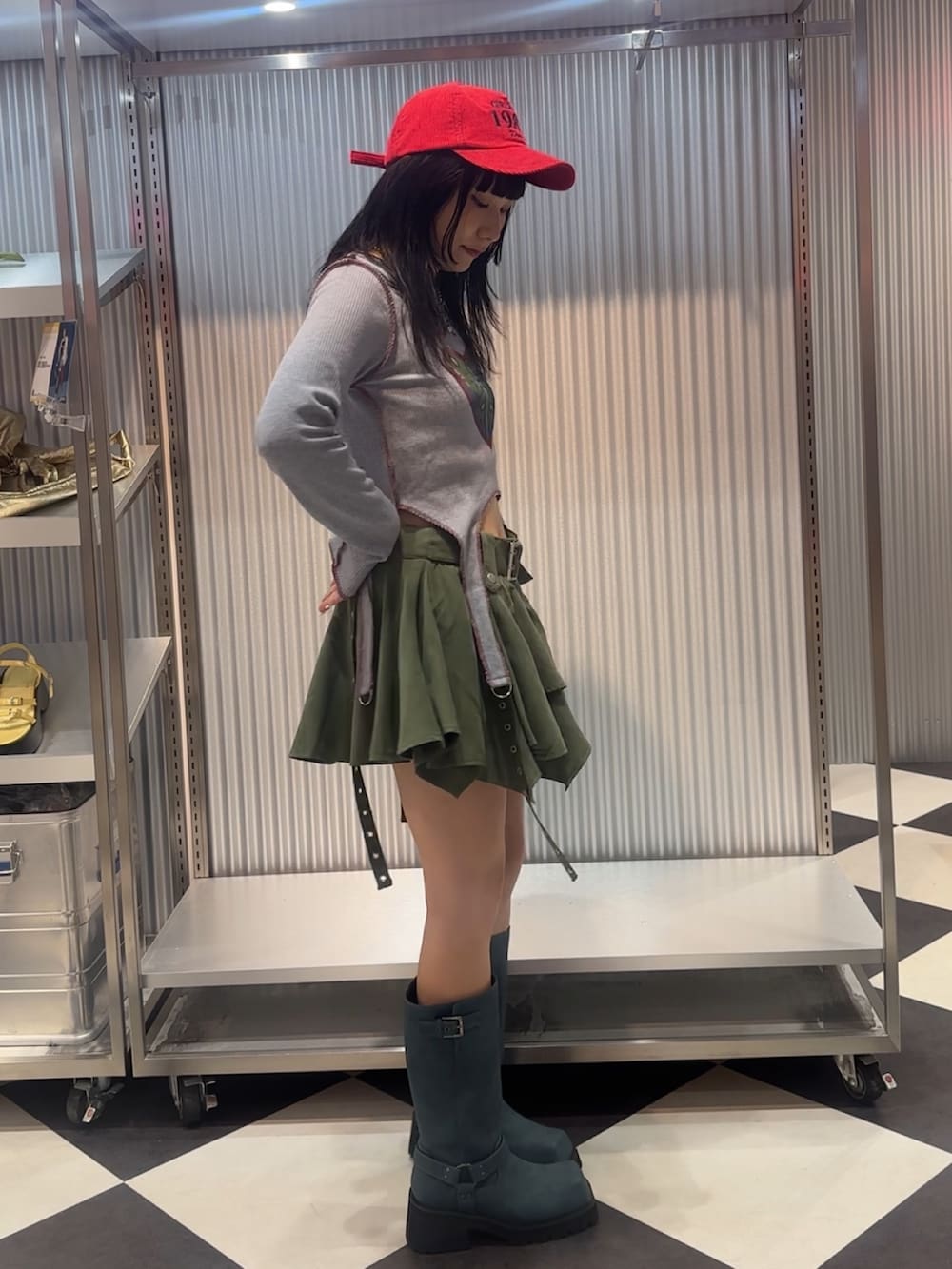 グリーン系のスカート、ブルー系のブーツ、ブルー系のTシャツ/カットソーを着用したレディースの秋コーディネートの2枚目の写真