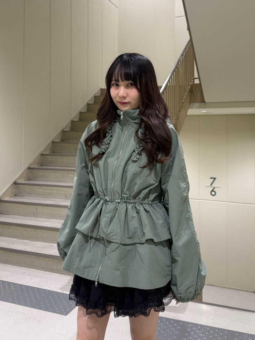 ブラック系のブーツ、グリーン系のナイロンジャケット、ブラック系のその他パンツを着用したレディースの春コーディネートの8枚目の写真