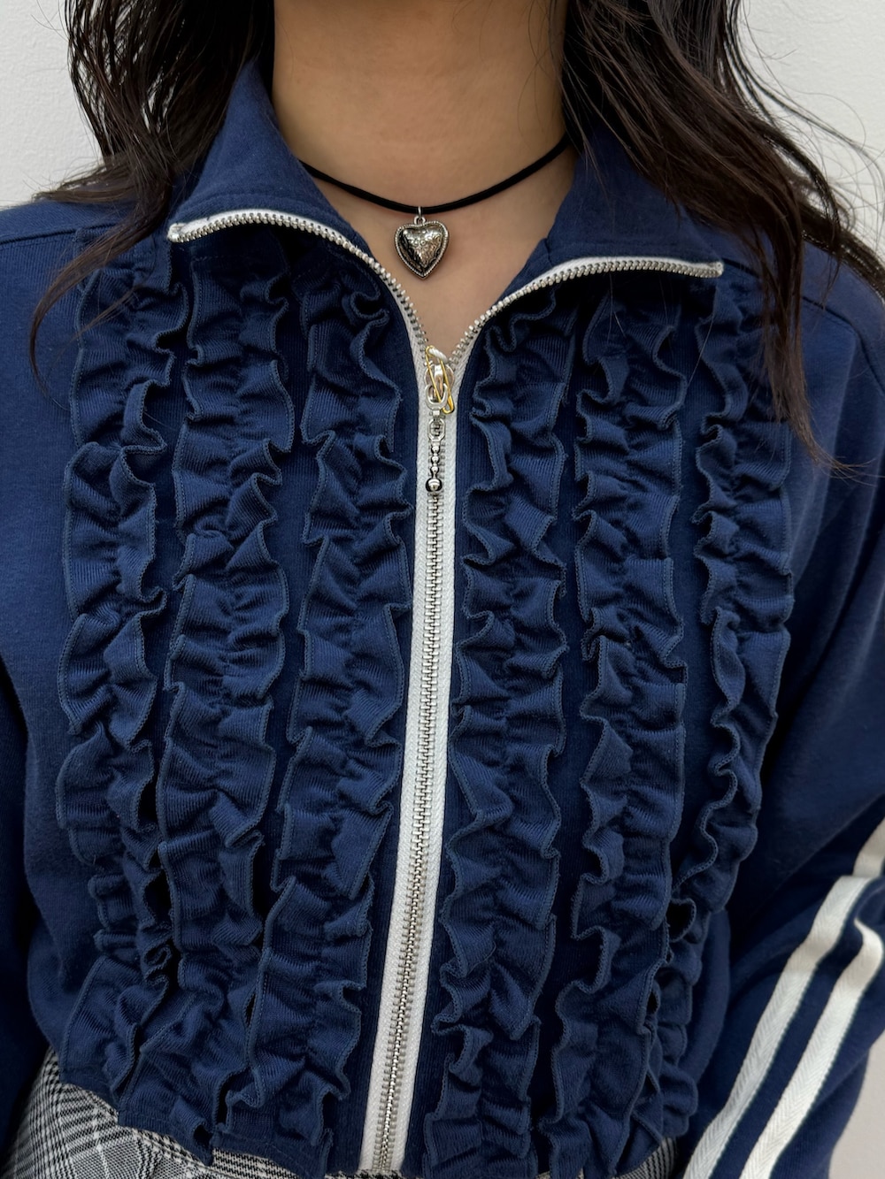 ブルー系のジャージ、グレー系のスカート、ブラック系のスニーカーを着用したレディースの春コーディネートの6枚目の写真